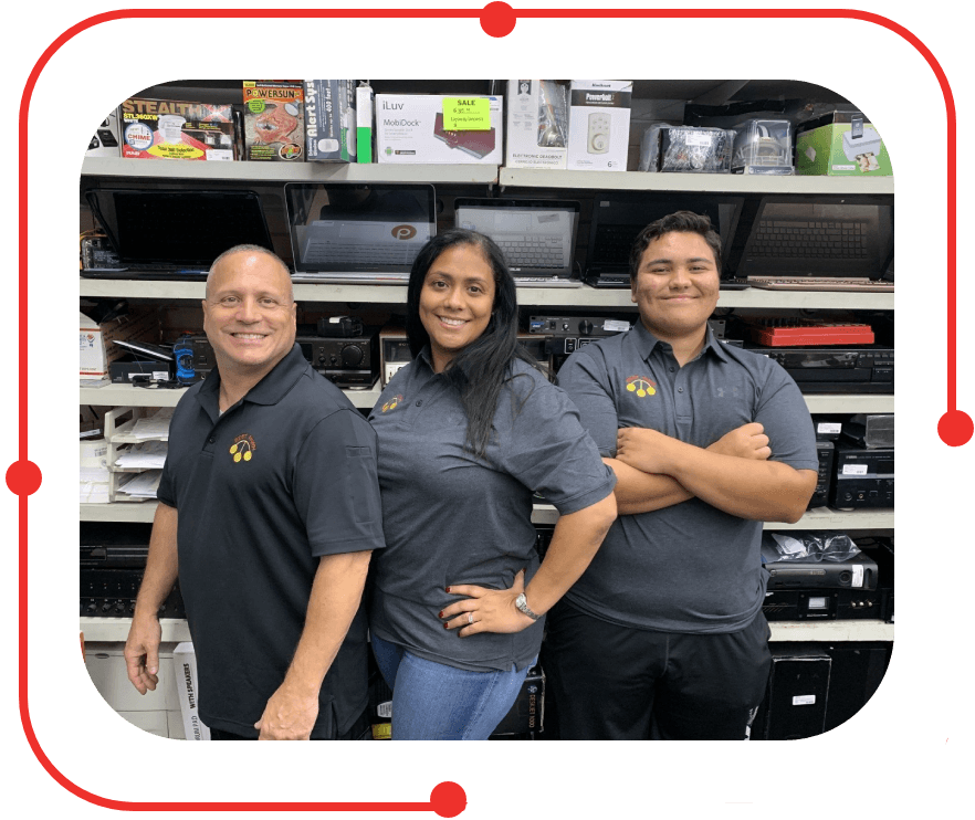 Three smiling retail employees posing in front of shelves with electronics.